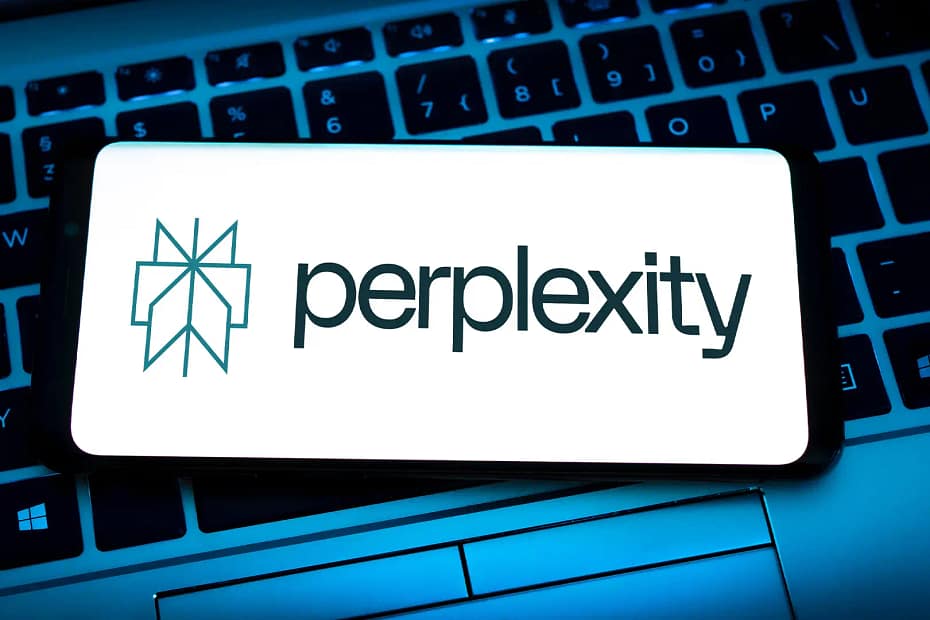 The Perplexity AI logo displayed on a smartphone screen resting on a backlit laptop keyboard, highlighting the brand's presence in the AI-powered search space.